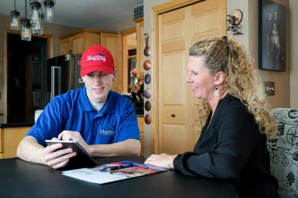 Masters Heating & Cooling speaking with an Indiana homeowner about their HVAC & plumbing systems