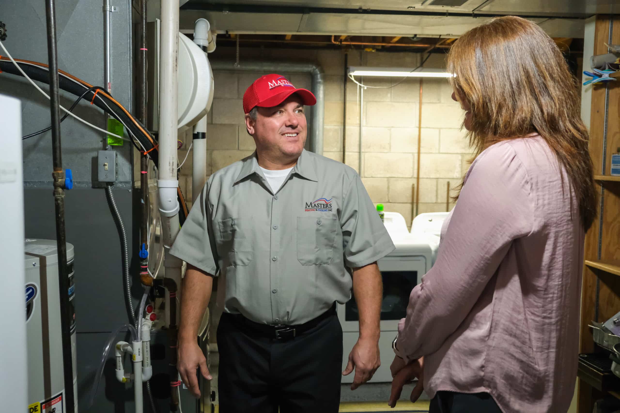Masters Heating, Cooling, Plumbing & Electrical technician speaking with a Decatur homeowner about their furnace