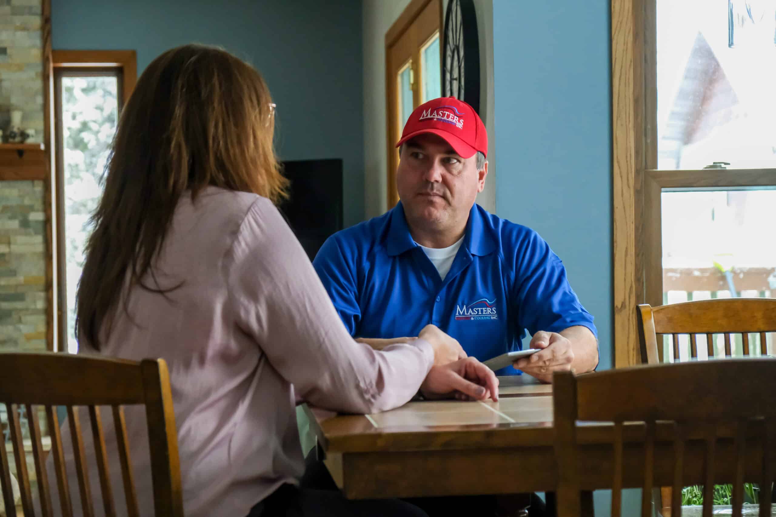 Masters Heating, Cooling, Plumbing & Electrical technician speaking with an Indiana homeowner 