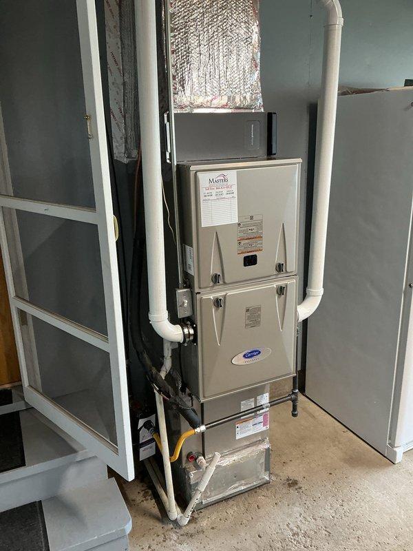 Churubusco, IN - Responded to post-installation warranty call for furnace installed recently. Customer reported whistling and rumbling noise in bedroom during unit operation. Performed thorough inspection of Carrier HVAC system installation, including vertically stacked heating and cooling units, ductwork connections, and all associated components. Examined flexible metallic supply duct, PVC condensate piping, gas line connections, and electrical conduit for proper installation and secure mounting. Documented system condition with photographs showing complete installation in mechanical room.