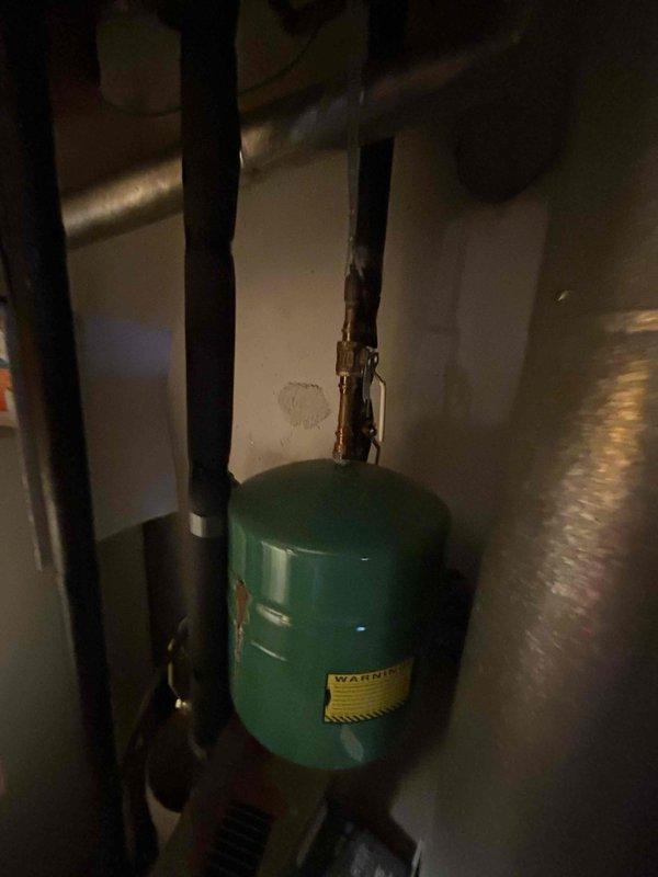 Responded to service call for boiler replacement estimate at residential property. Upon arrival, conducted thorough assessment of existing heating system located in basement mechanical room. Documented current equipment configuration including boiler unit, green expansion tank with visible corrosion on copper piping connections, pressure relief valve, and associated plumbing components. Photographed installation to provide detailed visual reference for replacement proposal. Communicated findings and coordinated with family member regarding system evaluation and replacement options for aging boiler equipment.