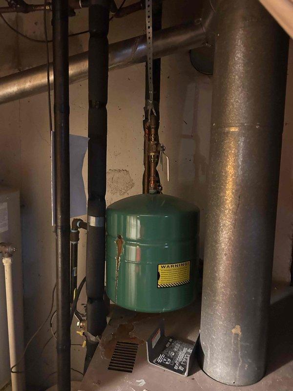 Responded to service call for boiler replacement estimate at residential property. Upon arrival, conducted thorough assessment of existing heating system located in basement mechanical room. Documented current equipment configuration including boiler unit, green expansion tank with visible corrosion on copper piping connections, pressure relief valve, and associated plumbing components. Photographed installation to provide detailed visual reference for replacement proposal. Communicated findings and coordinated with family member regarding system evaluation and replacement options for aging boiler equipment.