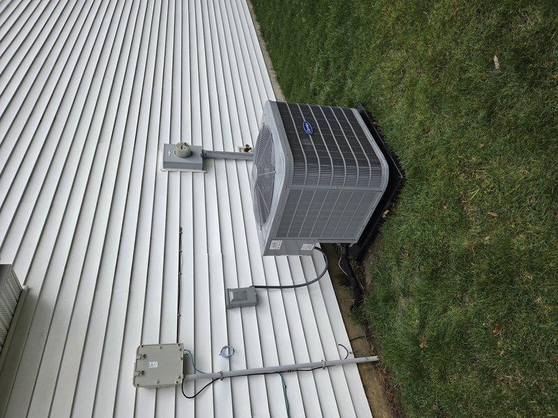 Huntertown, IN - Completed first prepaid cooling maintenance visit on rooftop-mounted Carrier condensing unit. Performed standard seasonal inspection including refrigerant line check, electrical disconnect verification, and overall system assessment. Unit and installation found to be in good working condition with proper mounting and secure line routing on corrugated metal roof surface.