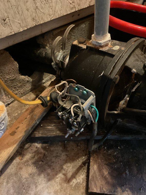 Paulding, OH - Responded to service call for newly installed tanked electric water heater in garage experiencing no water flow through pipes. Upon arrival, inspected the installation including the unit mounted on stand, associated piping, electrical connections, and pump system. Diagnosed water circulation issue and documented equipment configuration with photographs showing the mechanical components, PVC piping connections, electrical wiring, and pump assembly in the utility space.