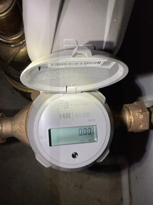 Completed installation of new Gerber two-piece toilet with associated supply piping and connections. Installed Badger Meter HR E/LCD digital water meter with brass fittings and isolation valves to monitor water consumption for the newly installed fixture. All plumbing connections were secured, tested for leaks, and verified operational with proper flow and shutoff capability.