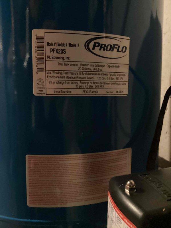 Completed full-day installation of comprehensive water treatment system including water softener, filtration unit, and 20-gallon ProFlo PFX20S well pressure tank. All components were professionally mounted to basement wall with proper copper piping connections, brass valve assemblies, and blue filter housing, with black containment drip pan installed at base to protect against potential leaks.