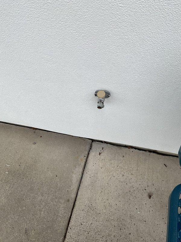 Responded to commercial plumbing service call addressing two issues: repaired continuously running toilet by accessing internal tank components through wall cavity and replaced defective exterior water spigot with new hose bib fixture mounted on building exterior wall.