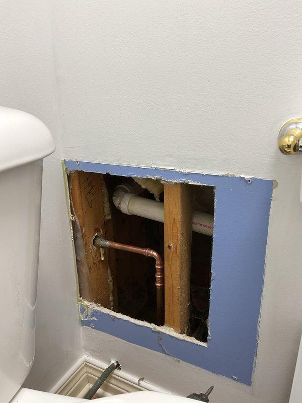 Responded to commercial plumbing service call addressing two issues: repaired continuously running toilet by accessing internal tank components through wall cavity and replaced defective exterior water spigot with new hose bib fixture mounted on building exterior wall.