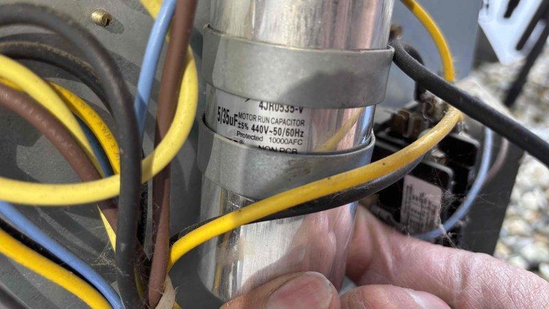 Completed first prepaid cooling maintenance visit on residential HVAC system. Performed comprehensive system diagnostics using digital clamp meter to verify electrical readings and amperage draw. Inspected motor run capacitor rated at 440V with 10,000 microfarad capacitance, confirmed proper operation and secure electrical connections across all wire terminals including yellow, blue, brown, and black conductors. Condenser coil inspected and found to be in clean condition with no debris obstruction. All system components operating within normal parameters.