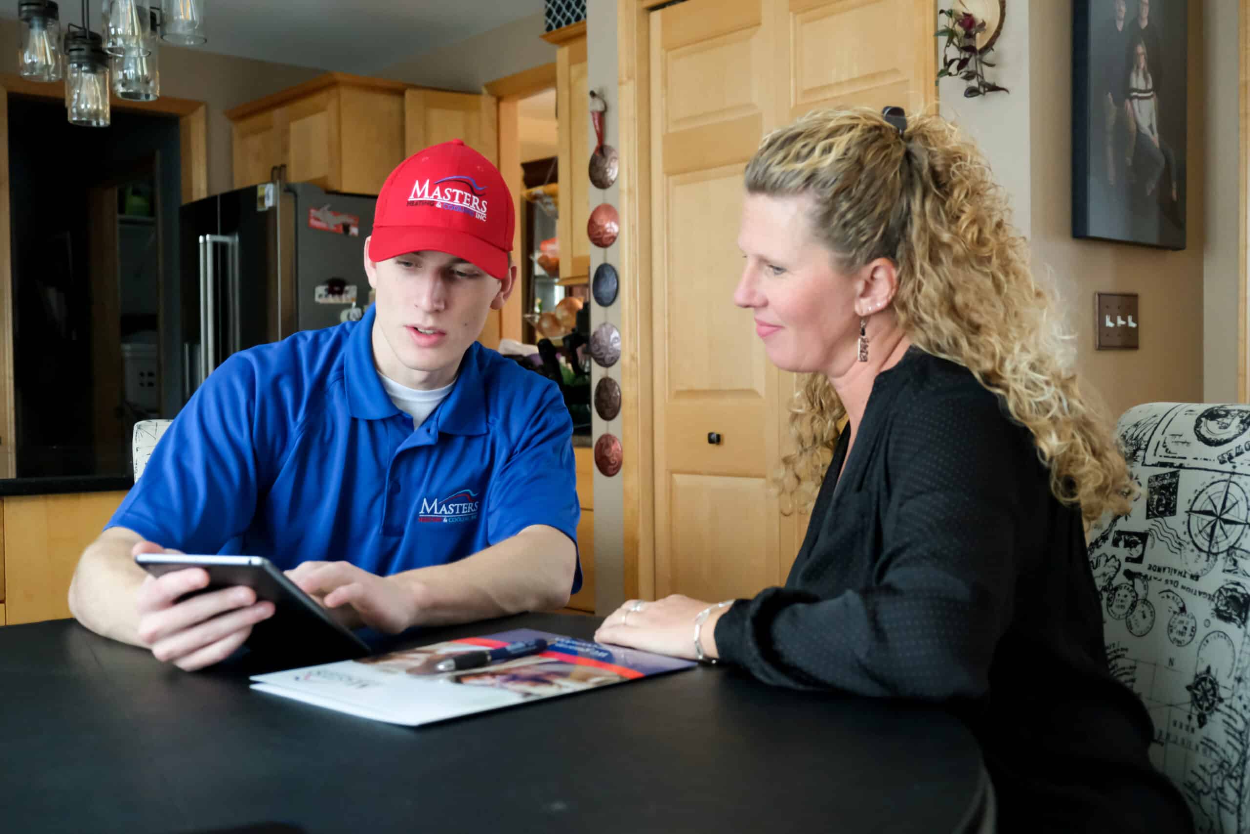 Masters Heating & Cooling technician speaking with a homeowner about upgrading their HVAC system