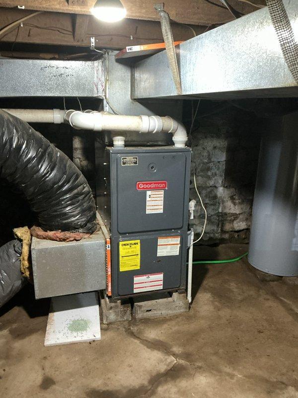 Conducted on-site assessment of existing Goodman furnace and air conditioning system for replacement quote due to equipment age. Inspected basement mechanical room installation, documenting current furnace configuration including PVC venting, ductwork connections, and electrical service. Evaluated existing system specifications from manufacturer labels and assessed accessibility for replacement equipment. Photographed furnace unit, surrounding mechanical components, ductwork layout, and basement access points to determine installation requirements and equipment sizing for replacement proposal.